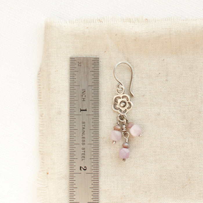 A mini cactus flower lilac earring next to a ruler for size reference