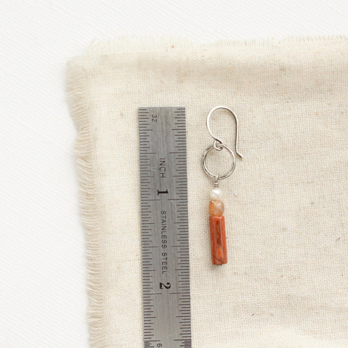 A canyon sydney hoop earring next to a ruler for size reference.