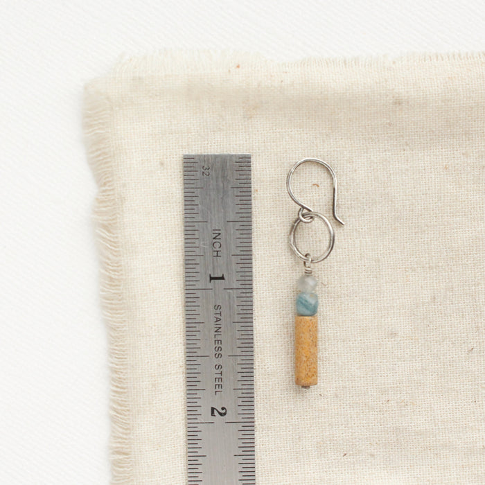 A oasis sydney hoop earring next to a ruler for size reference.