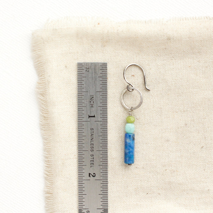 A cobalt sydney hoop earring next to a ruler for size reference.