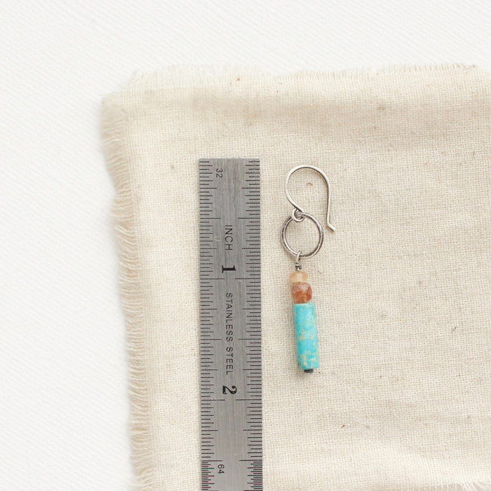A cascade sydney hoop earring next to a ruler for size reference.