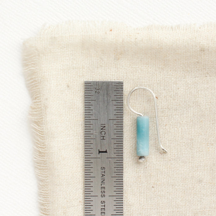 A larimar lobe hugger earring next to a ruler for size reference.