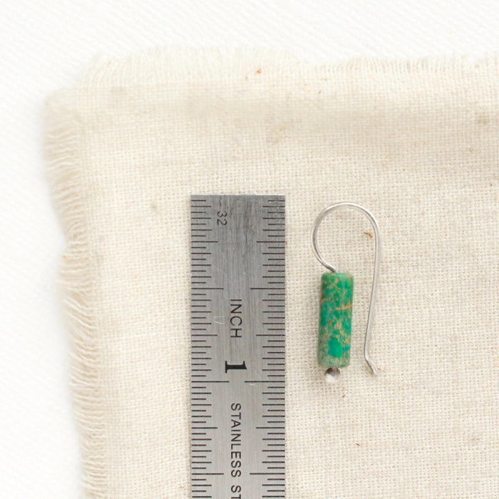 A green sediment jasper lobe hugger earring next to a ruler for size reference.