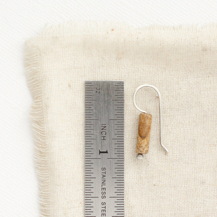 A picture jasper lobe hugger earring next to a ruler for size reference.