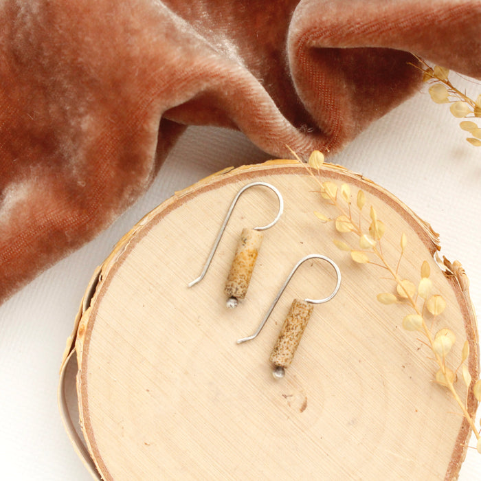 The picture jasper lobe hugger earrings styled on wood with orange velvet and dried grass.