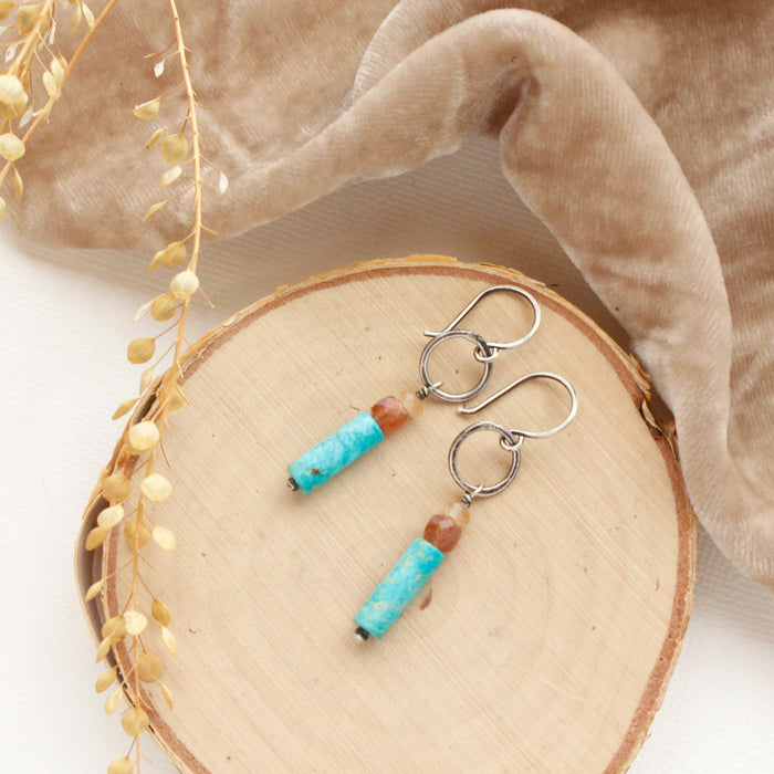 The cascade sydney hoop earrings styled on wood with tan velvet and dried grass.