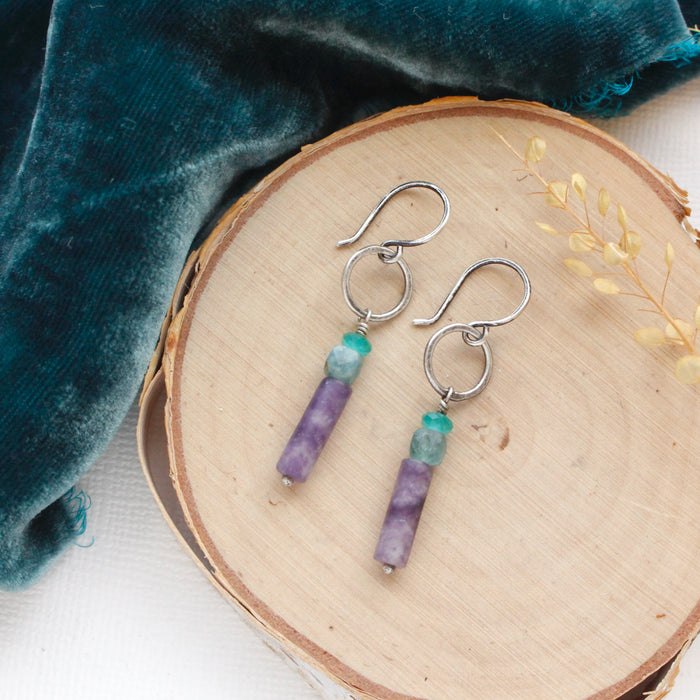 The twilight sydney hoop earrings styled on wood with blue velvet and dried grass.