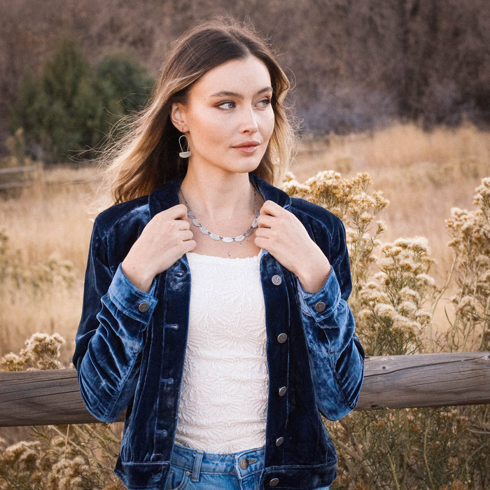 A model wearing the asmi long loop earrings and asmi full collar necklace