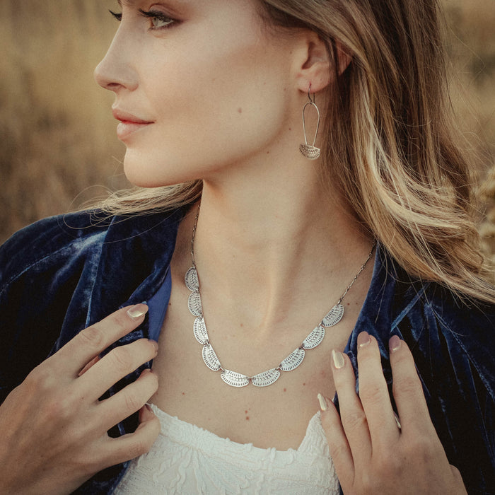 A model wearing the asmi full collar necklace and matching earrings