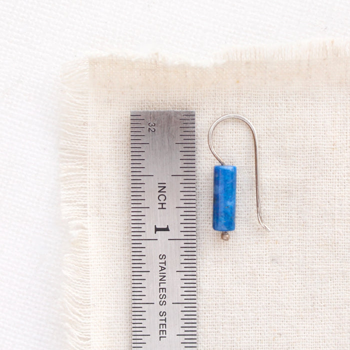 A lapis lobe hugger earring next to a ruler for size reference