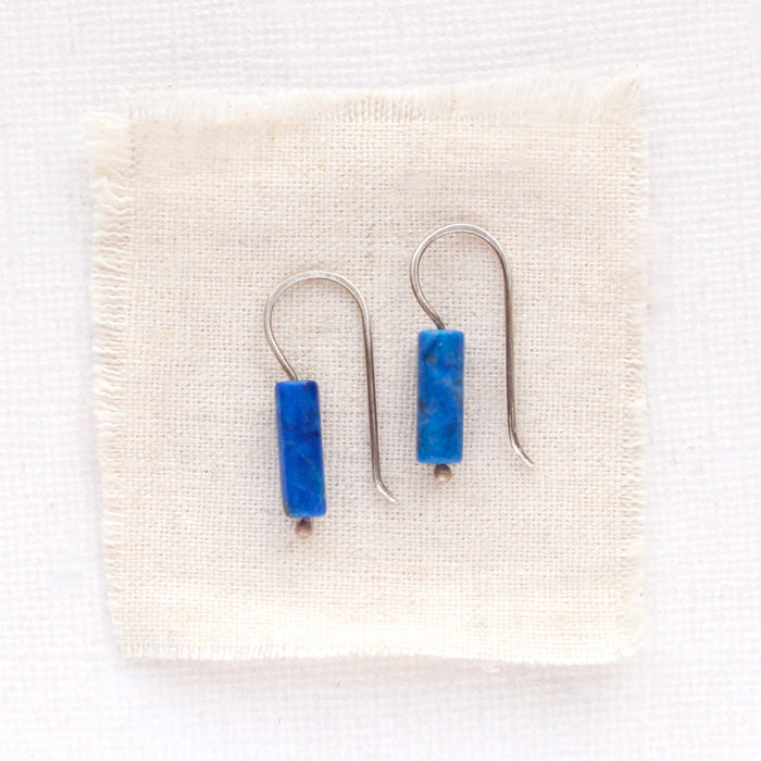 The lapis lobe hugger earrings styled on tan linen