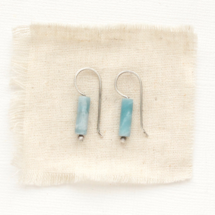 The larimar lobe hugger earrings styled on tan linen.