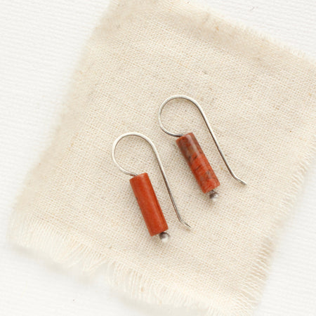 The red jasper lobe hugger earrings styled on tan linen.