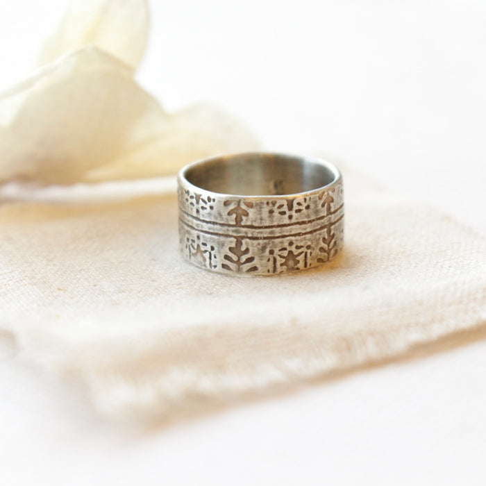 The nordic stamped band ring styled on tan linen