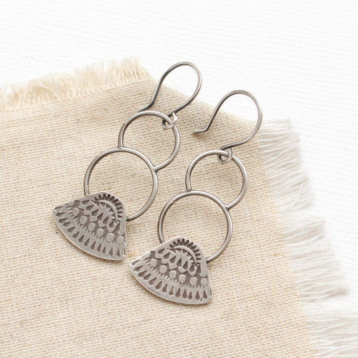 the asmi triangle double loop earrings styled on tan linen