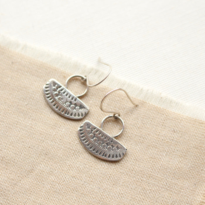 Stamped silver Asmi with loop earrings styled on tan linen