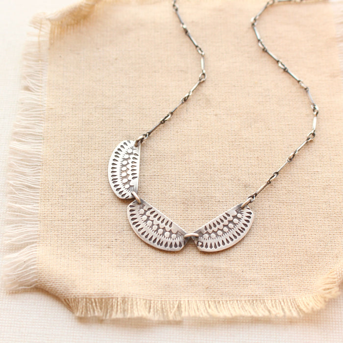 The asmi trio collar necklace styled on tan linen