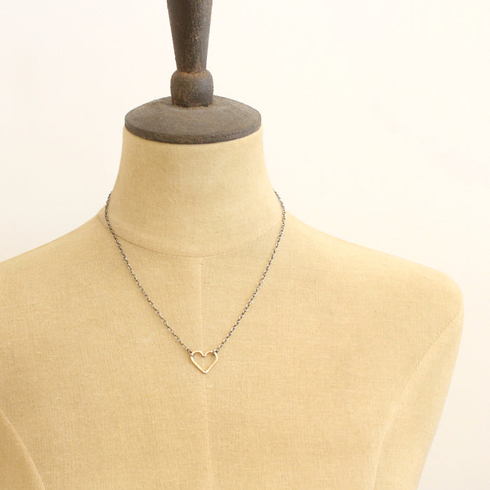 A mannequin wearing the mixed metal floating heart necklace