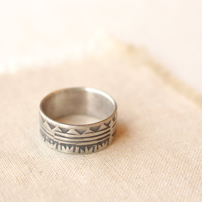 The rustic tribal stamped ring styled on tan linen