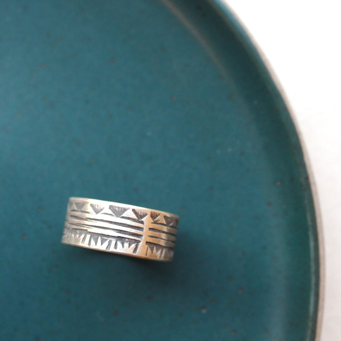 The rustic tribal stamped ring styled on a blue plate