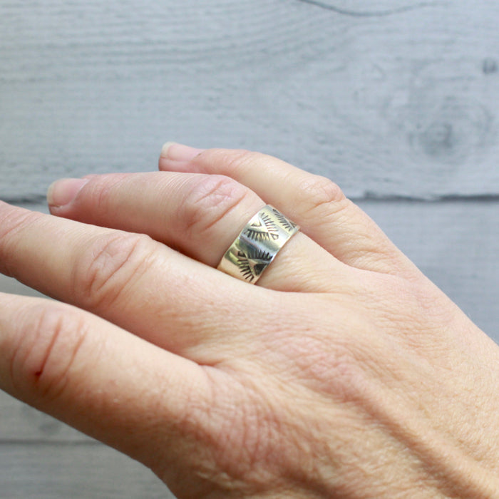 The stamped feathered band ring styled on a hand to show size reference