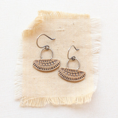 The asmi short loop bronze and silver earrings styled on tan linen