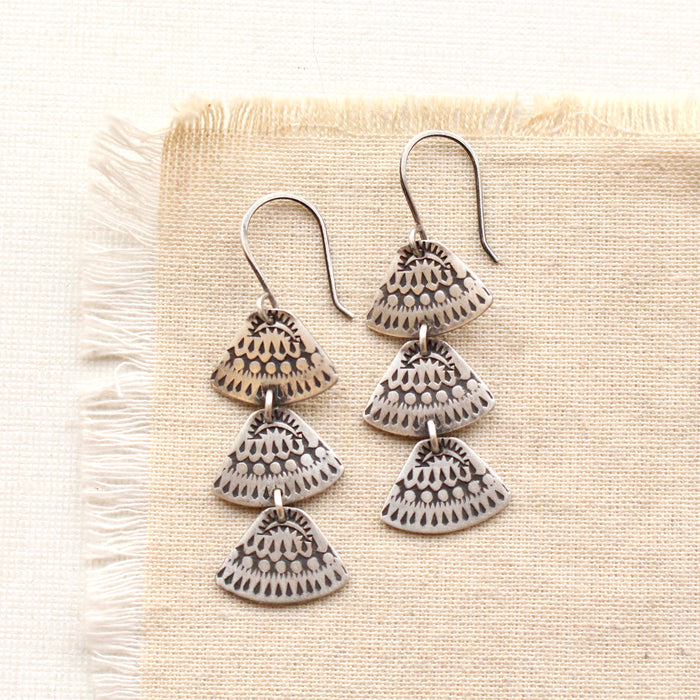 the asmi trio triangle long earrings styled on tan linen