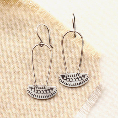 The asmi silver long loop earrings styled on tan linen