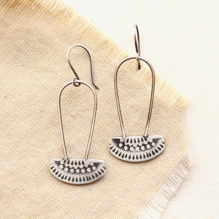 The asmi silver long loop earrings styled on tan linen