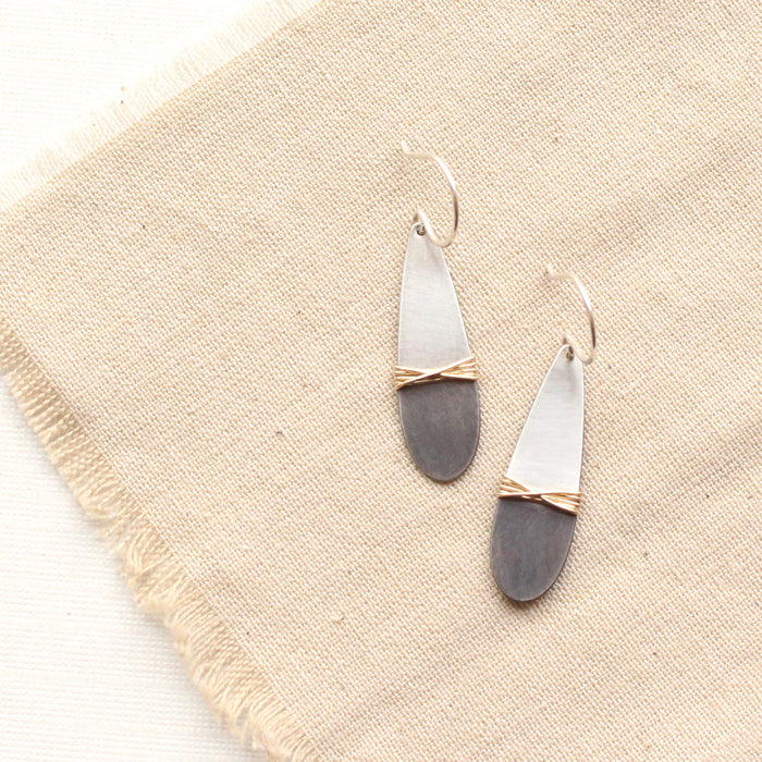 The rustic dipped teardrop mixed metal earrings styled on tan linen