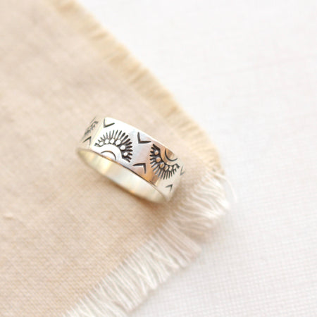 The indian sun stamped band ring styled on tan linen