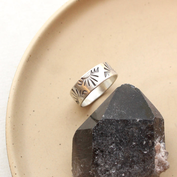 The sunrise hawk band ring is styled on a tan plate with a black crystal