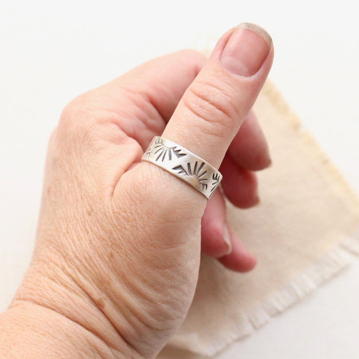 The sunrise hawk ring styled on a hand to show size reference
