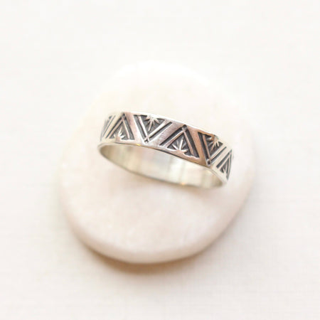 The stamped triangle silver ring styled on a white stone