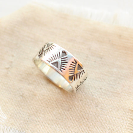 The stamped feathered triangle wide band ring styled on tan linen