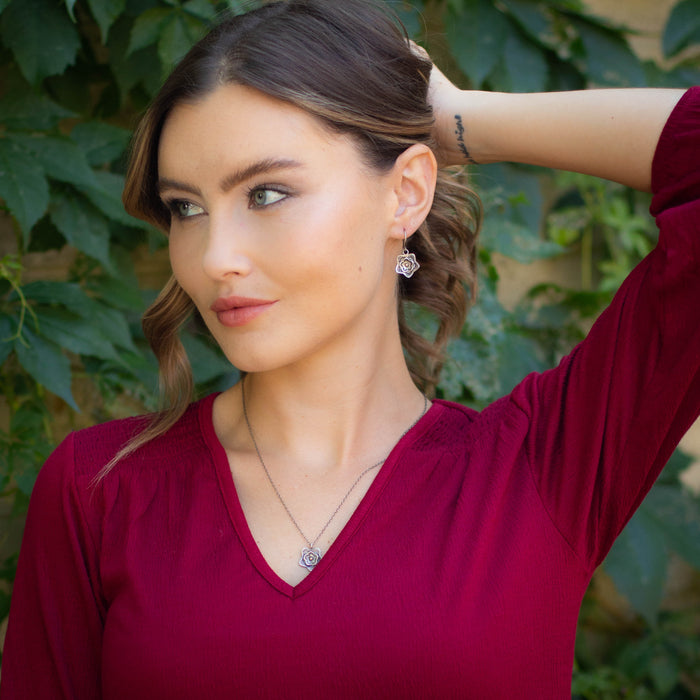 A model wearing the layered cactus flower mixed metal earrings