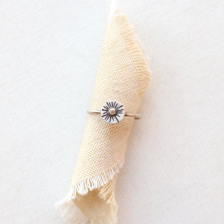 The little sun mixed metal ring styled on tan linen