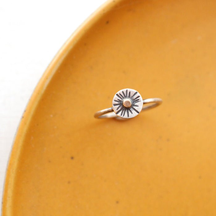 The little mixed metal sun ring styled on a yellow plate