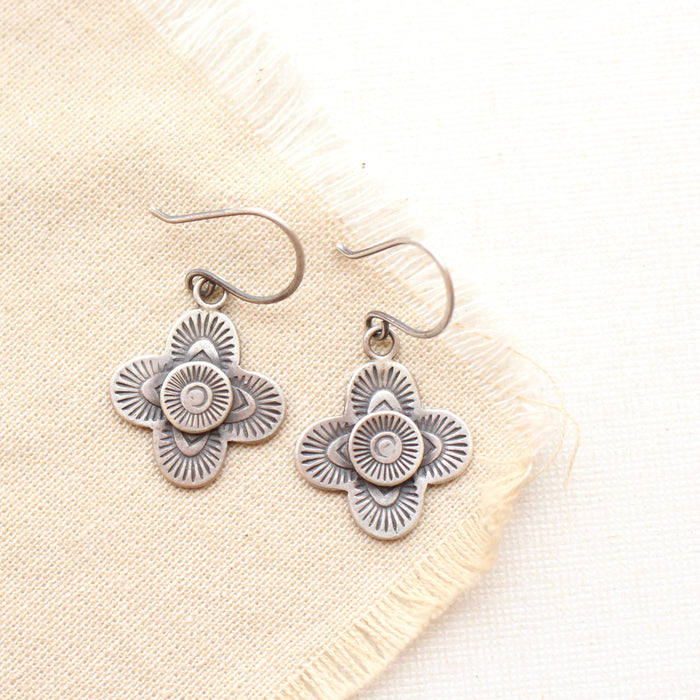 The stamped silver layered talara earrings styled on tan linen