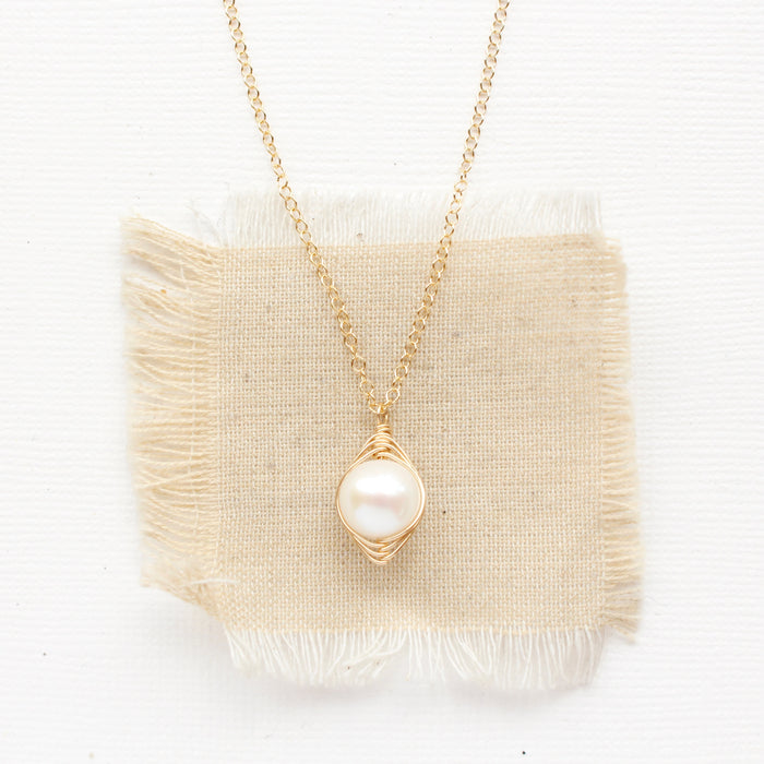 The perfect pearl gold necklace styled on tan linen