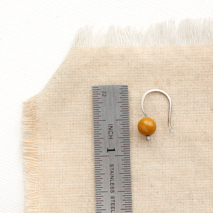 A mookaite lobe hugger next to a ruler for size reference