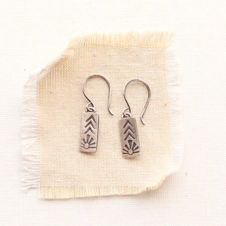 mini sun bar earrings on tan linen