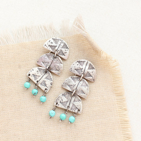 The pakal trio turquoise dangle post earrings styled on tan linen