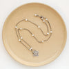 The layered talara pearl necklace styled on a tan plate to show the adjustable lobster clasp closure