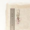 A mini cactus flower lilac earring next to a ruler for size reference