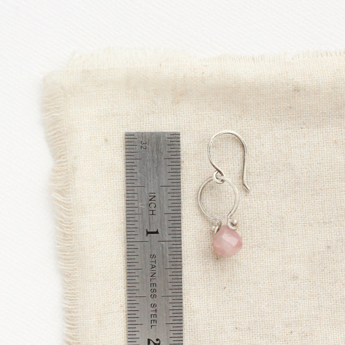 A madagascar rose quartz la cloche earring next to a ruler for size reference