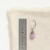 A kunzite drop earring next to a ruler for size reference