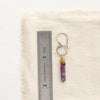 A zinnia sydney hoop earring next to a ruler for size reference
