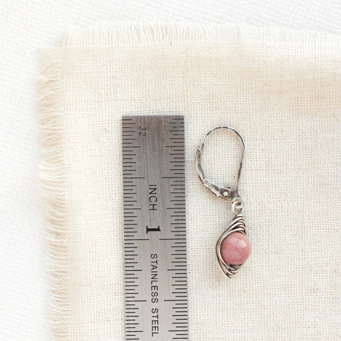 A perfect wrap pink rhodonite wrap earring next to a ruler for size reference