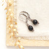 The perfect wrap onyx earrings styled on limestone with linen and dried grass